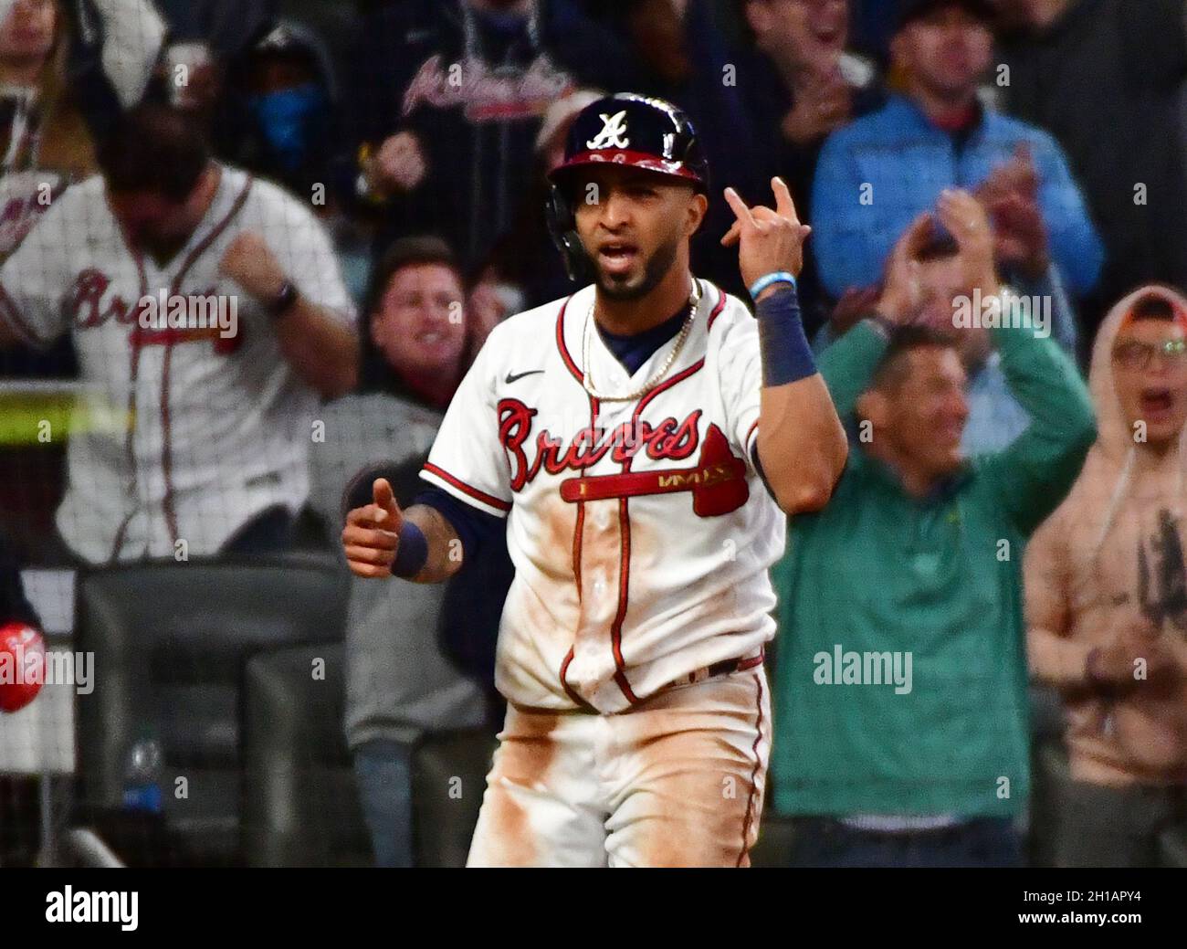 Atlanta Braves' Ozzie Albies has his chain in his teeth after diving into  third base on a long fly ball by Ronald Acuna Jr. against the San Francisco  Giants during the first