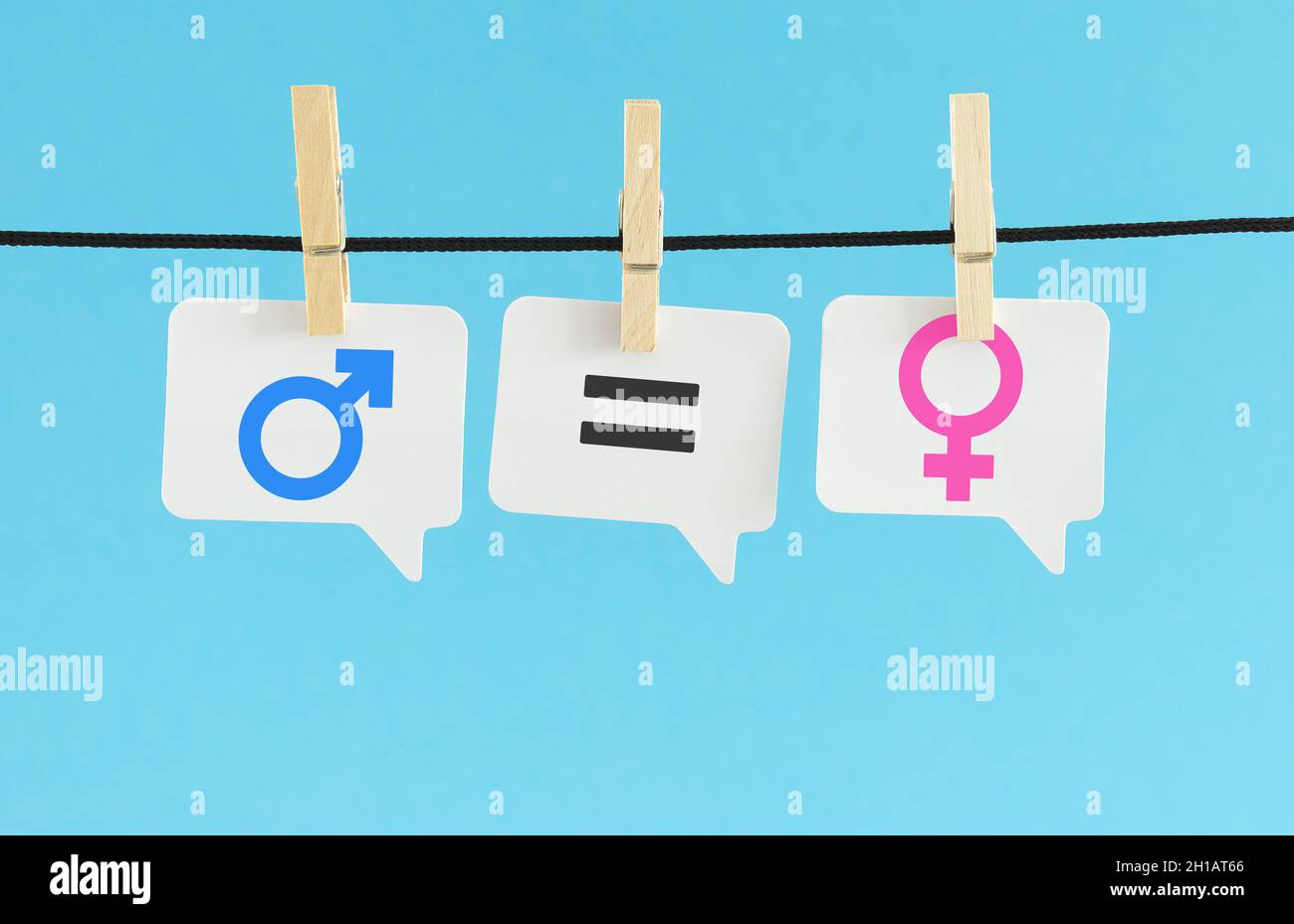 Gender equality, sexism and sexual equality concept with a blue male and a pink female icon and the equal to sign symbols on white paper speech bubble Stock Photo