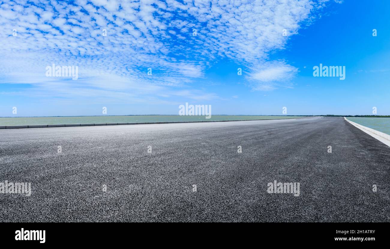 Empty asphalt road and blue sky with white clouds Stock Photo - Alamy