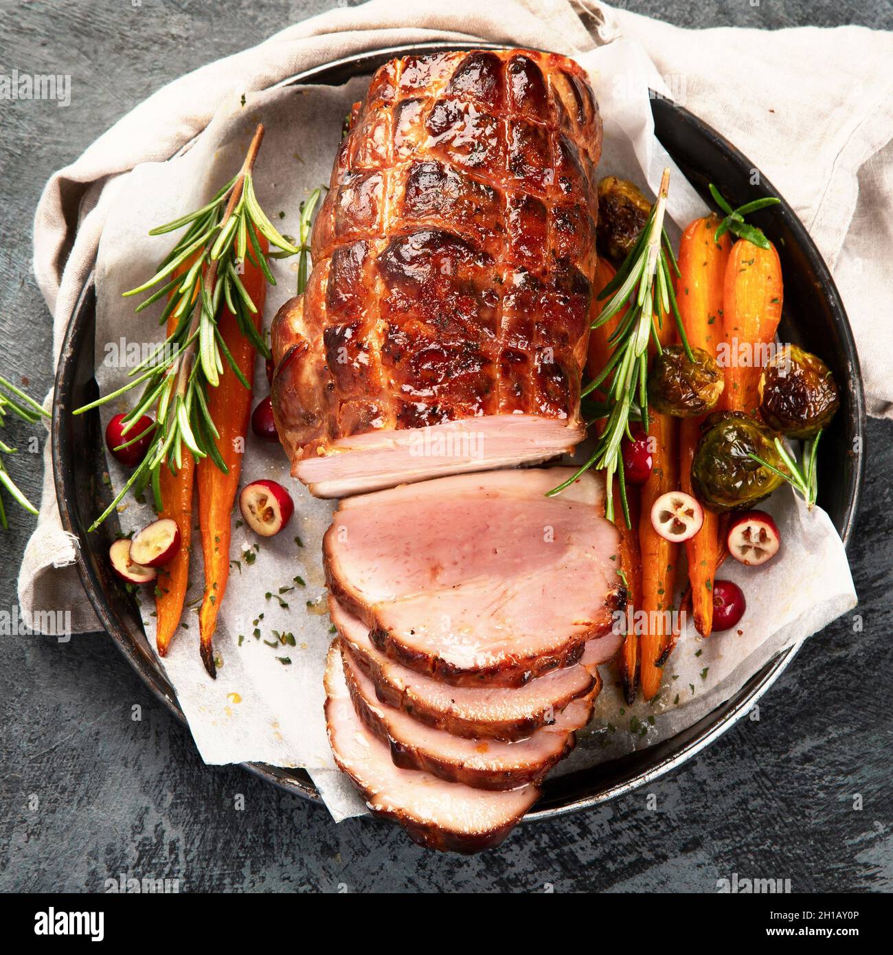 Baked ham with vegetables on dark background. Traditional food concept