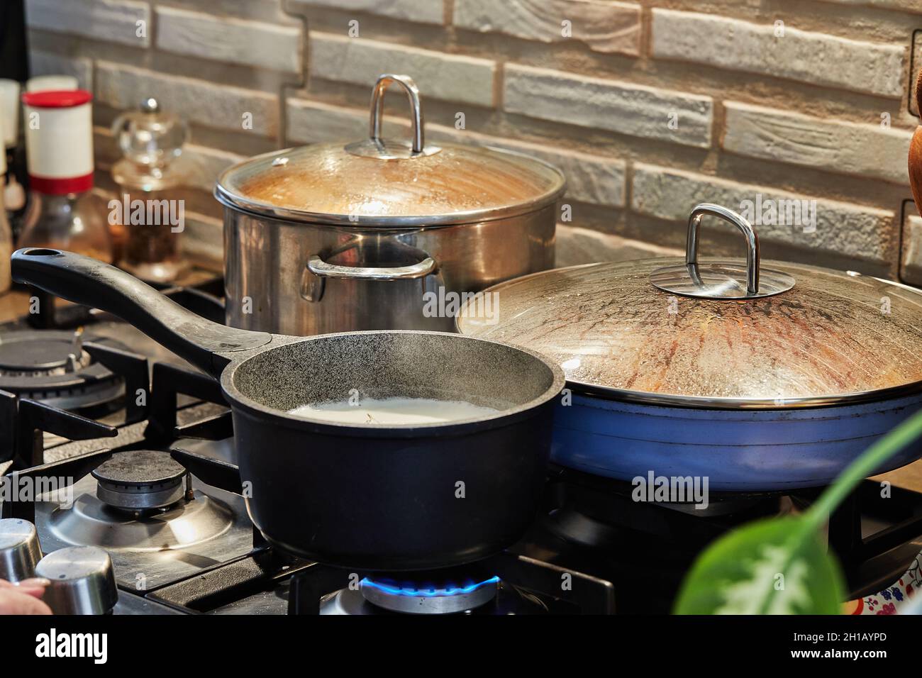 Preparing food in frying pan and casseroles on the gas stove in the ...