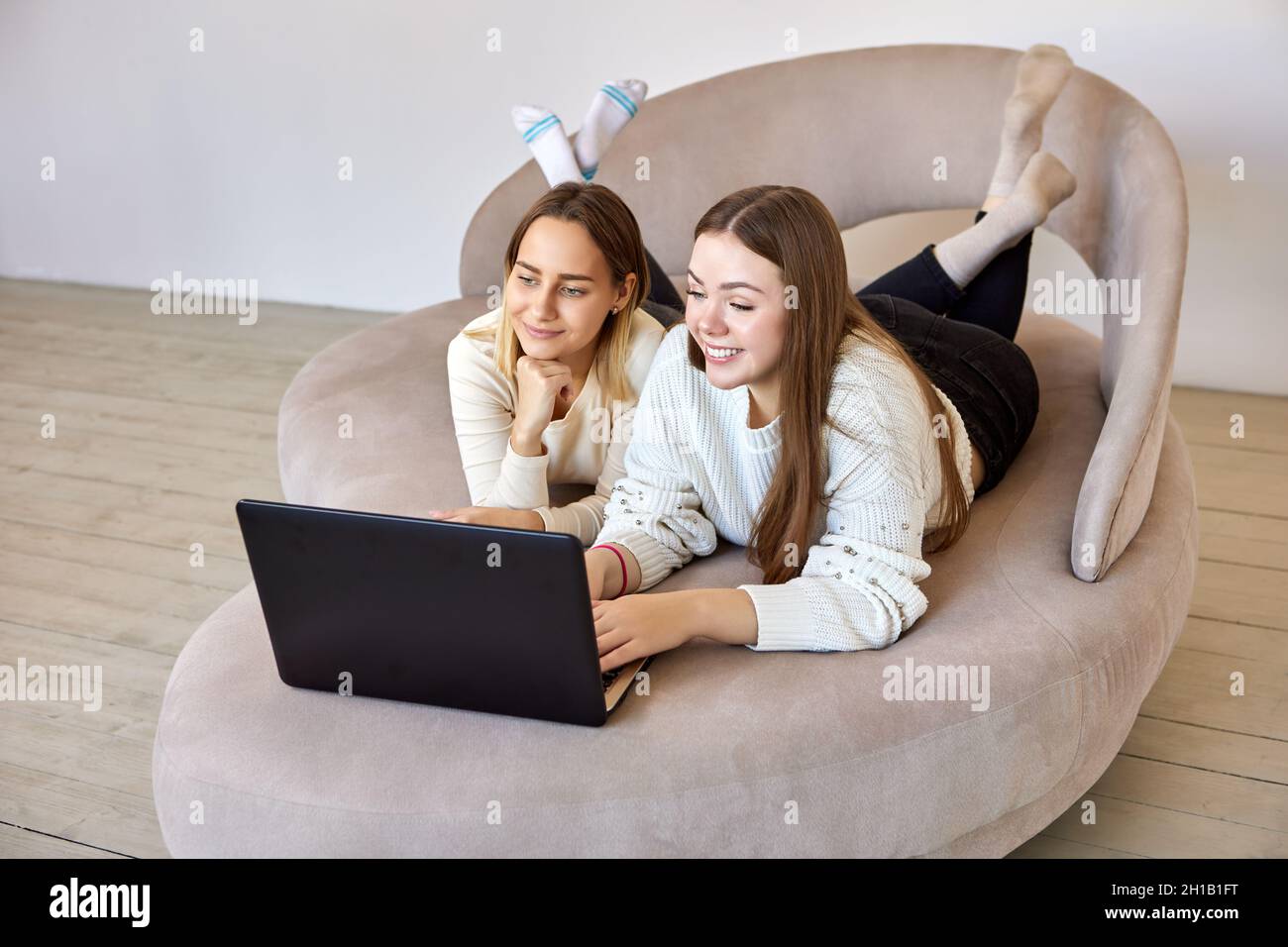 Two sisters lying on sofa hi-res stock photography and images - Alamy