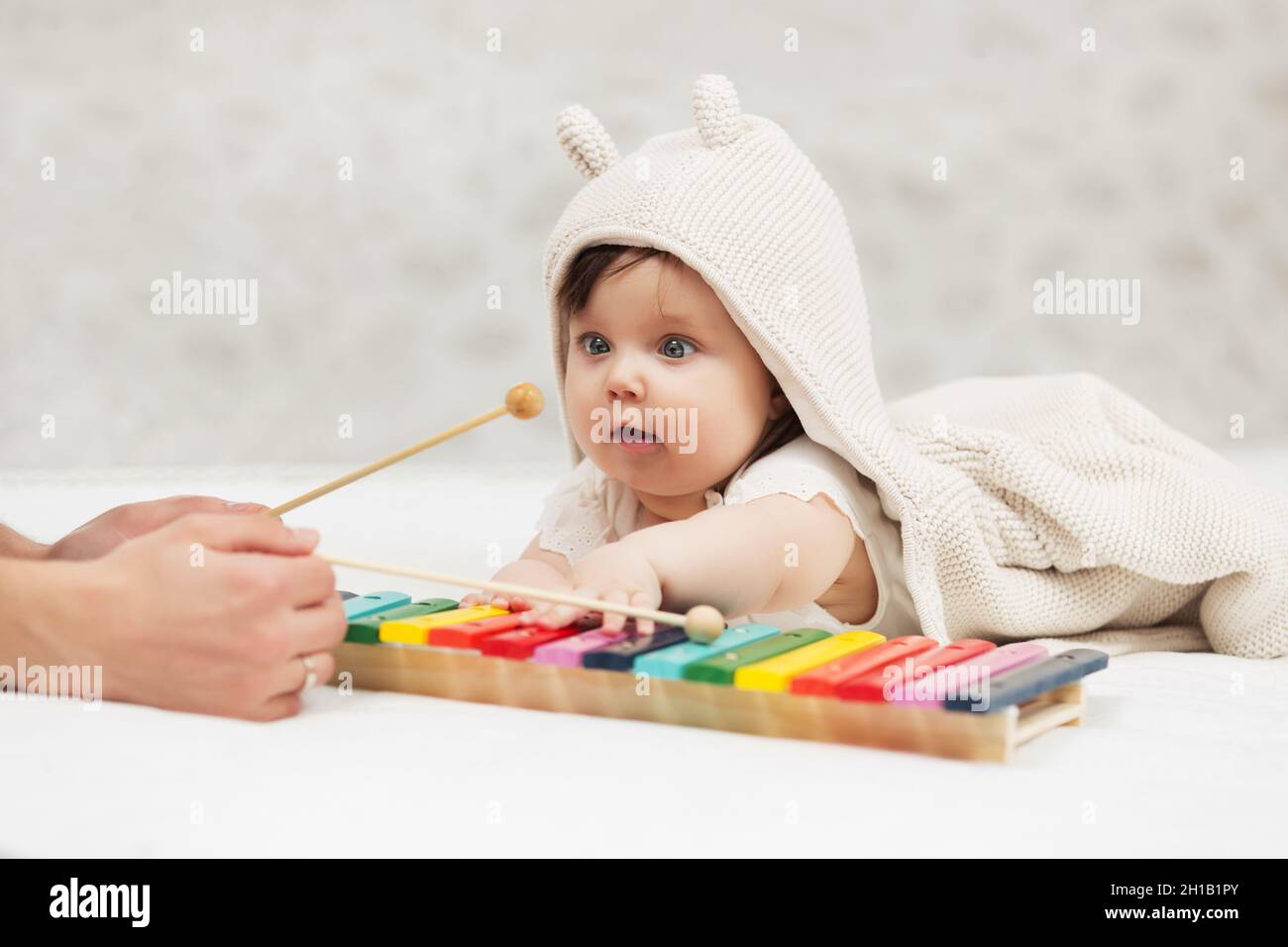 Half year baby girl playing with xylophone toy on blanket at home Stock Photo