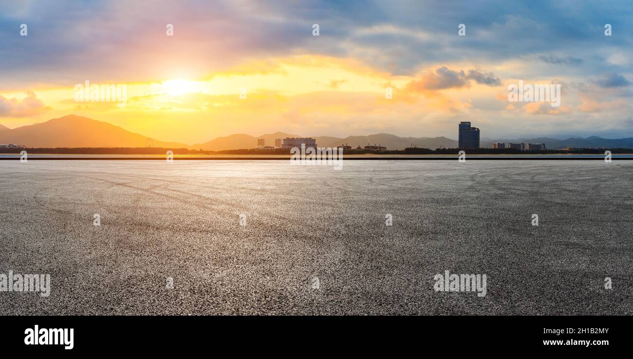 Empty asphalt road and city skyline with mountain at sunset Stock Photo ...