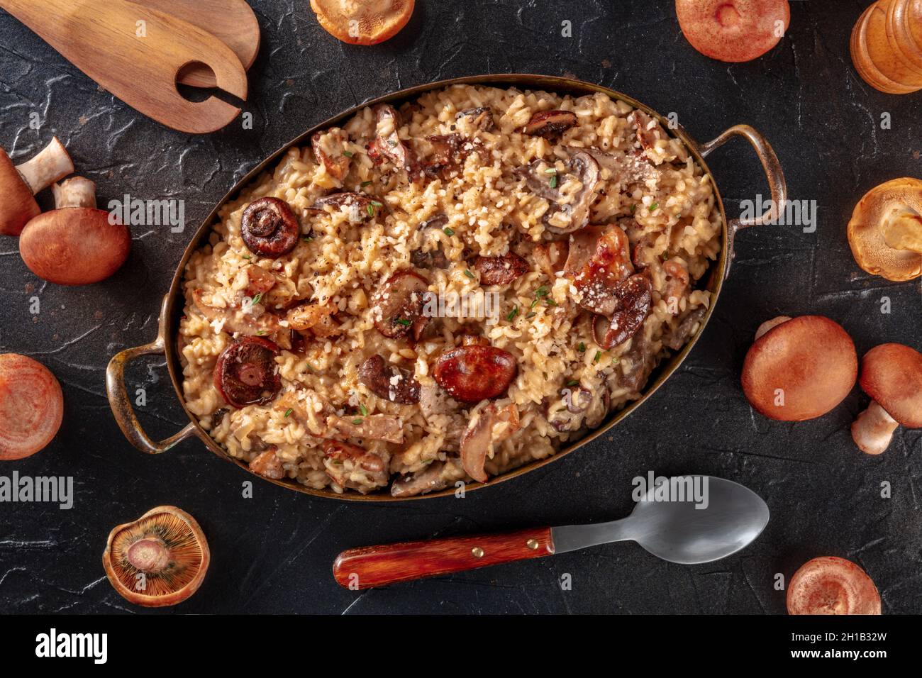 Risotto ai funghi, mushroom rice, with ingredients, overhead flat lay shot on a black background