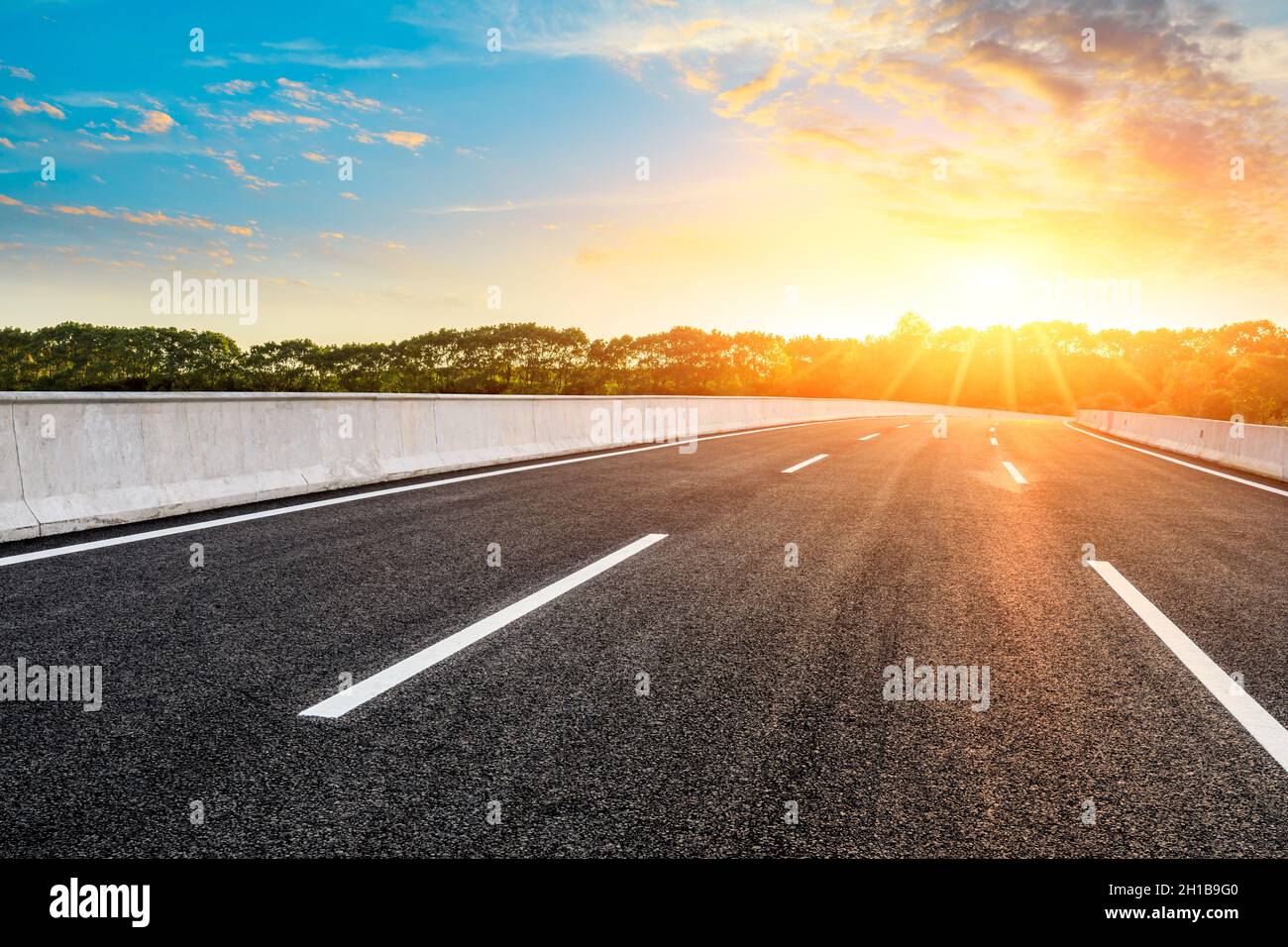 Empty asphalt road and green tree scenery at sunrise Stock Photo - Alamy