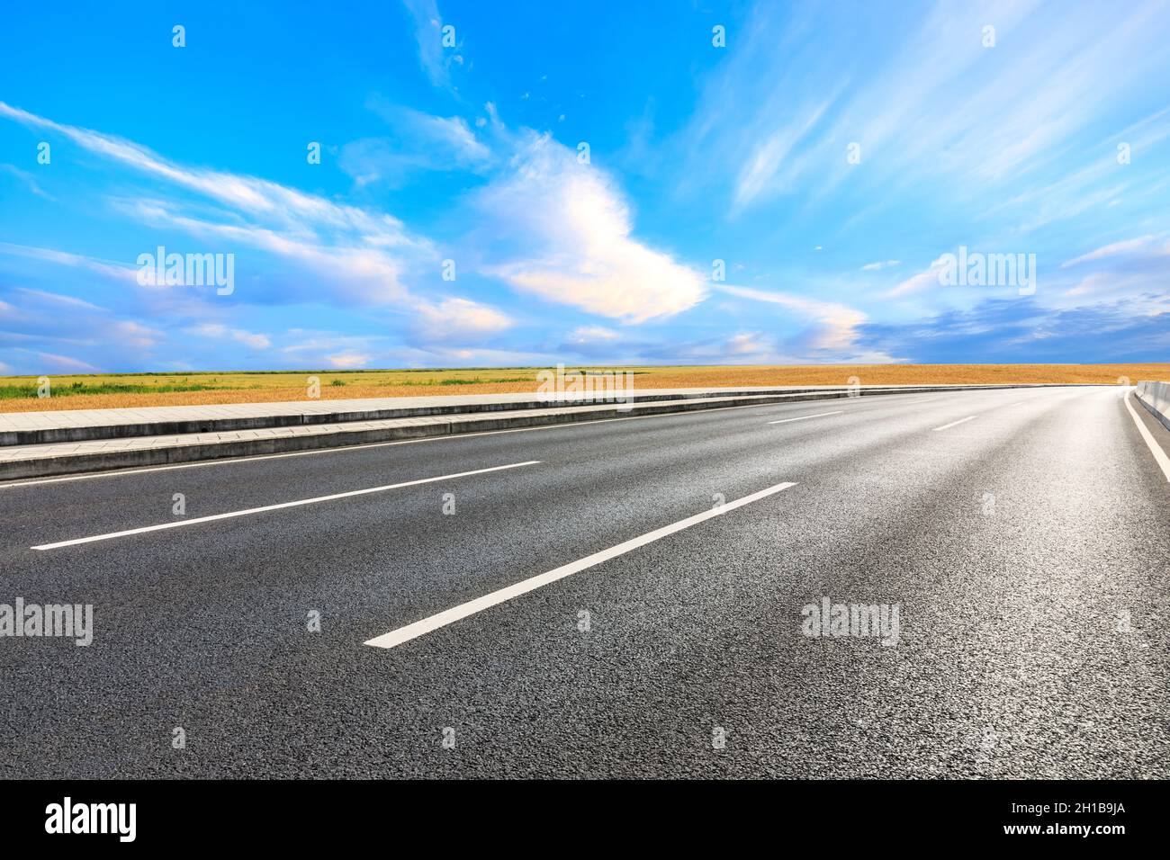 Empty asphalt road and ripe wheat fields scenery Stock Photo - Alamy