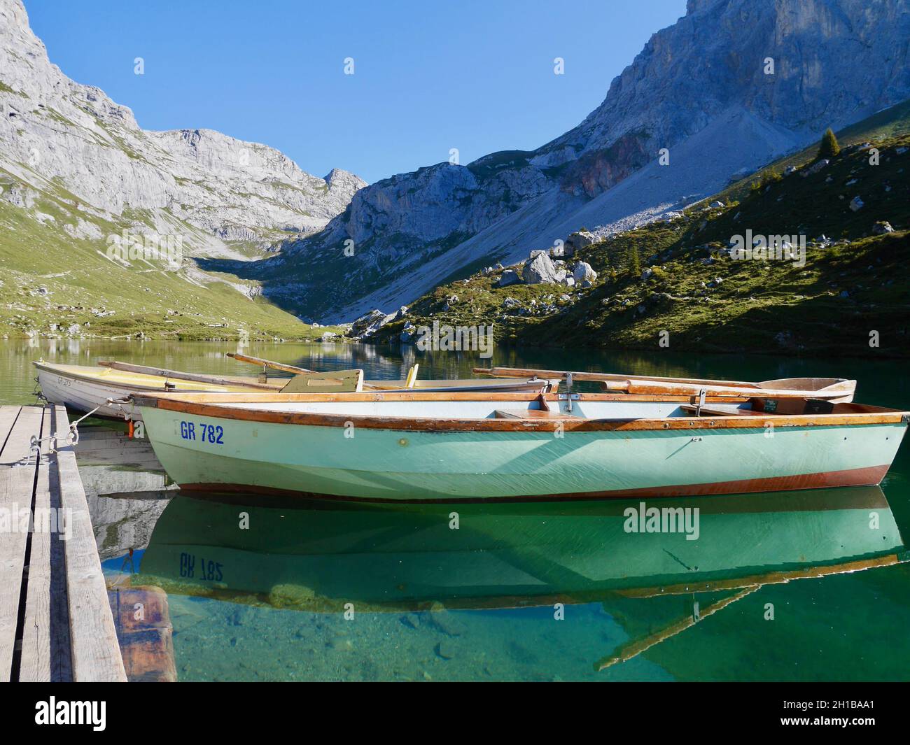 Boats in emerald green Lake Partnun in Praettigau, Graubuenden, Switzerland. Stock Photo