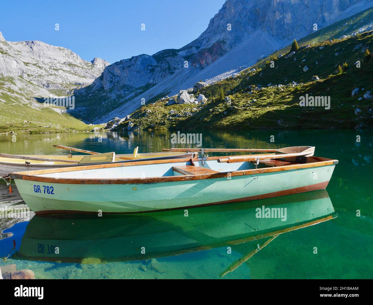 Boats in emerald-green Lake Partnun in Praettigau, Graubuenden, Switzerland. Stock Photo