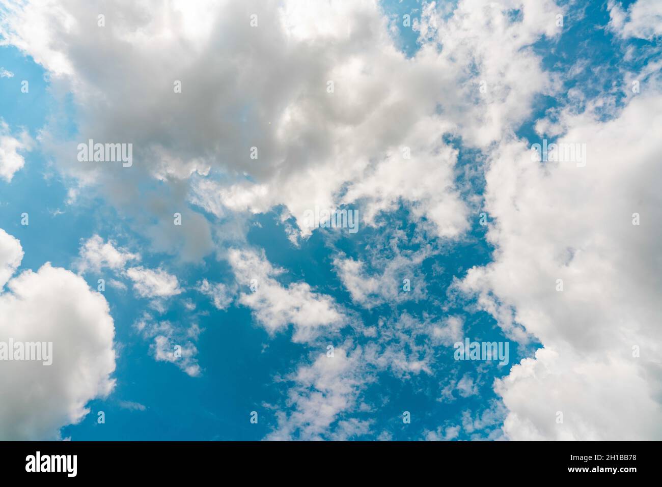 Beautiful blue sky and white cumulus clouds abstract background. Cloudscape background. Blue sky and fluffy white clouds on sunny day. Nature weather. Stock Photo