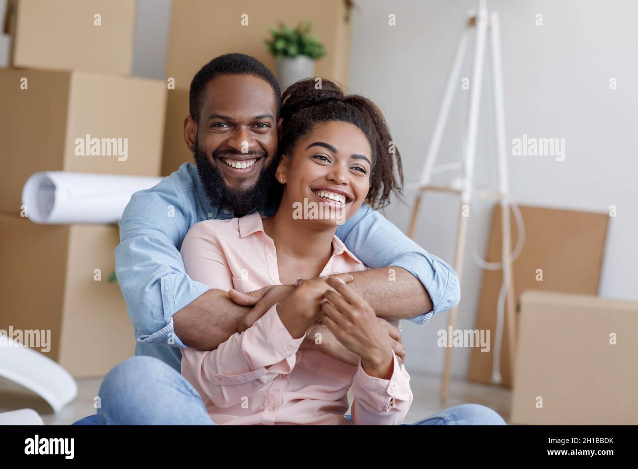 Happy young african american husband and wife resting at moving ...