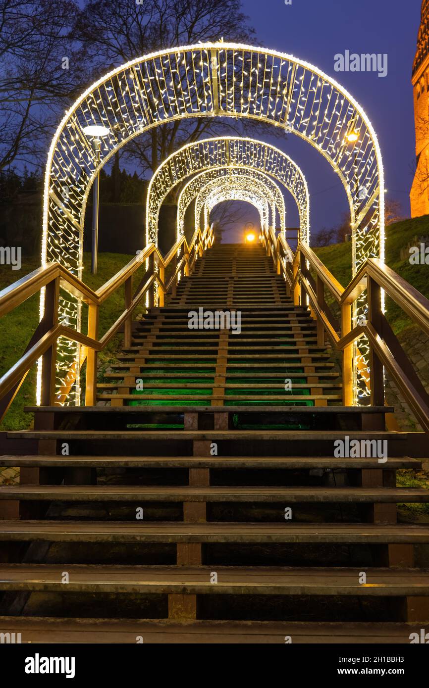 Holiday illumination at night on a hillside with long wooden stairs