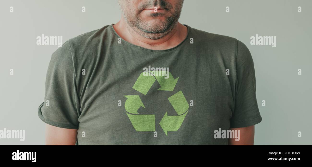 Man wearing green t-shirt with universal recycling symbol printed on chest, portrait of environmentalist and environmental activist Stock Photo
