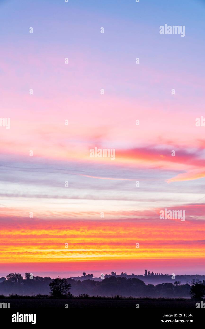 Very dramatic dawn sky over a mist covered Kent Landscape with some