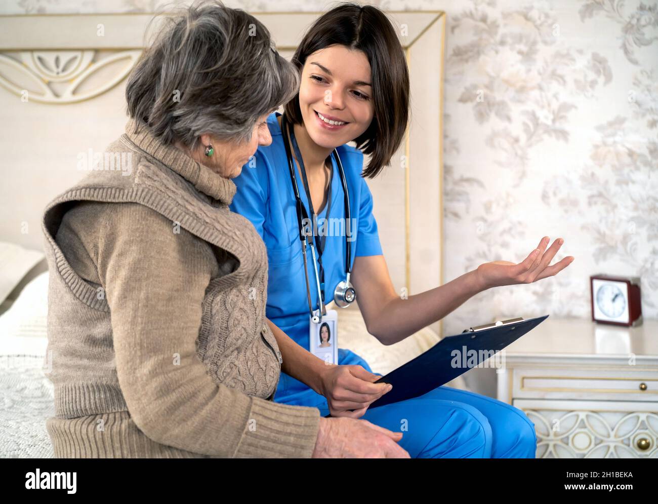Young nurse is caring for an elderly 80 year-old woman at home. Stock Photo