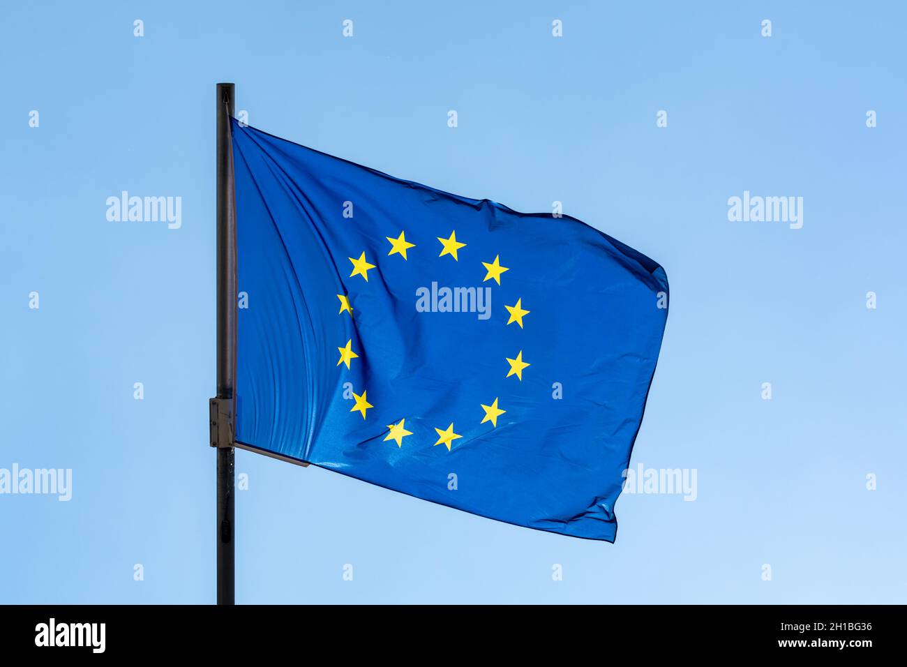 Blue with yellow stars flag of European Union waving on flagpole and ...