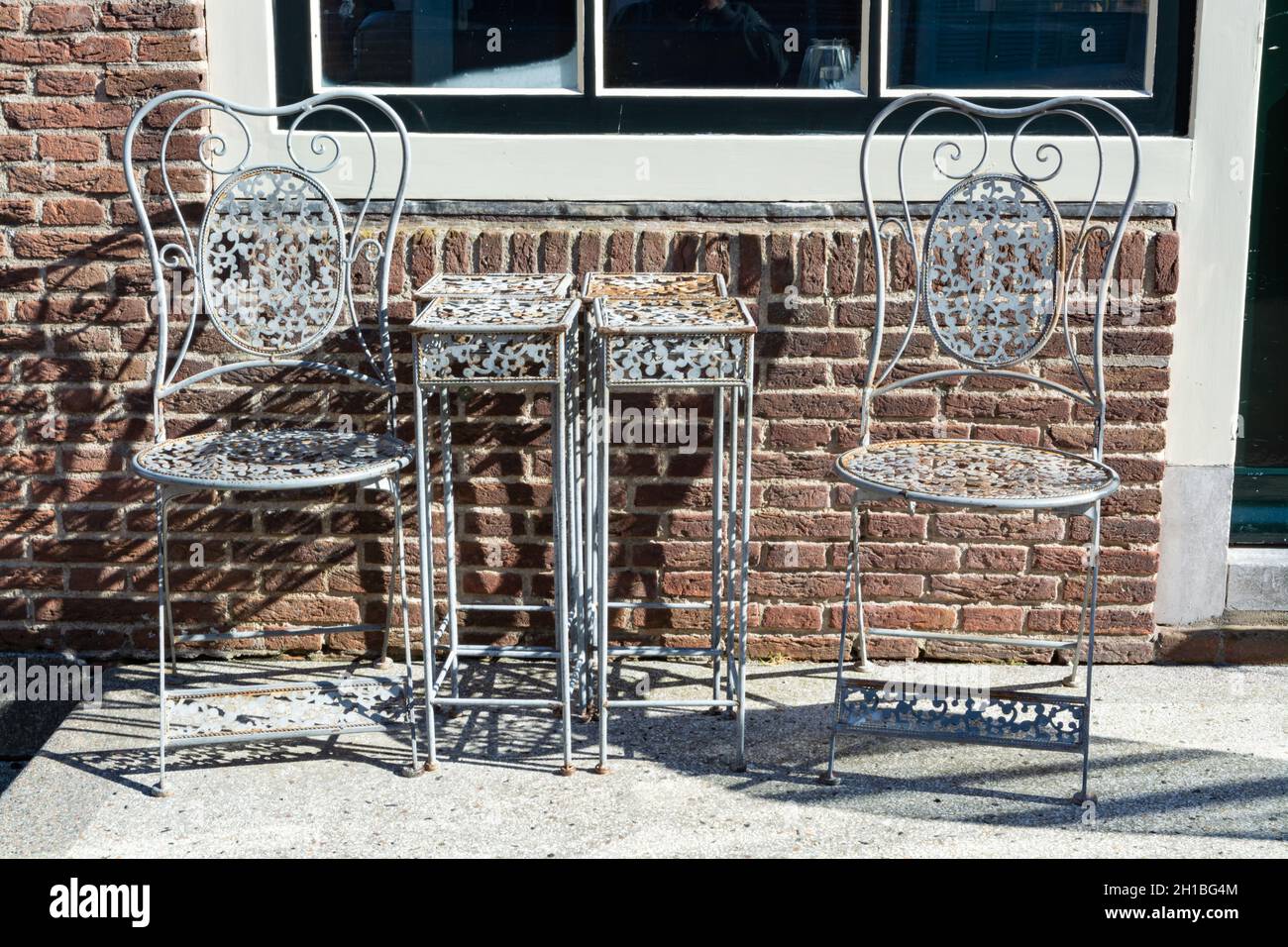 Vintage metal bistro table and chairs set in outdoor cafe, used for