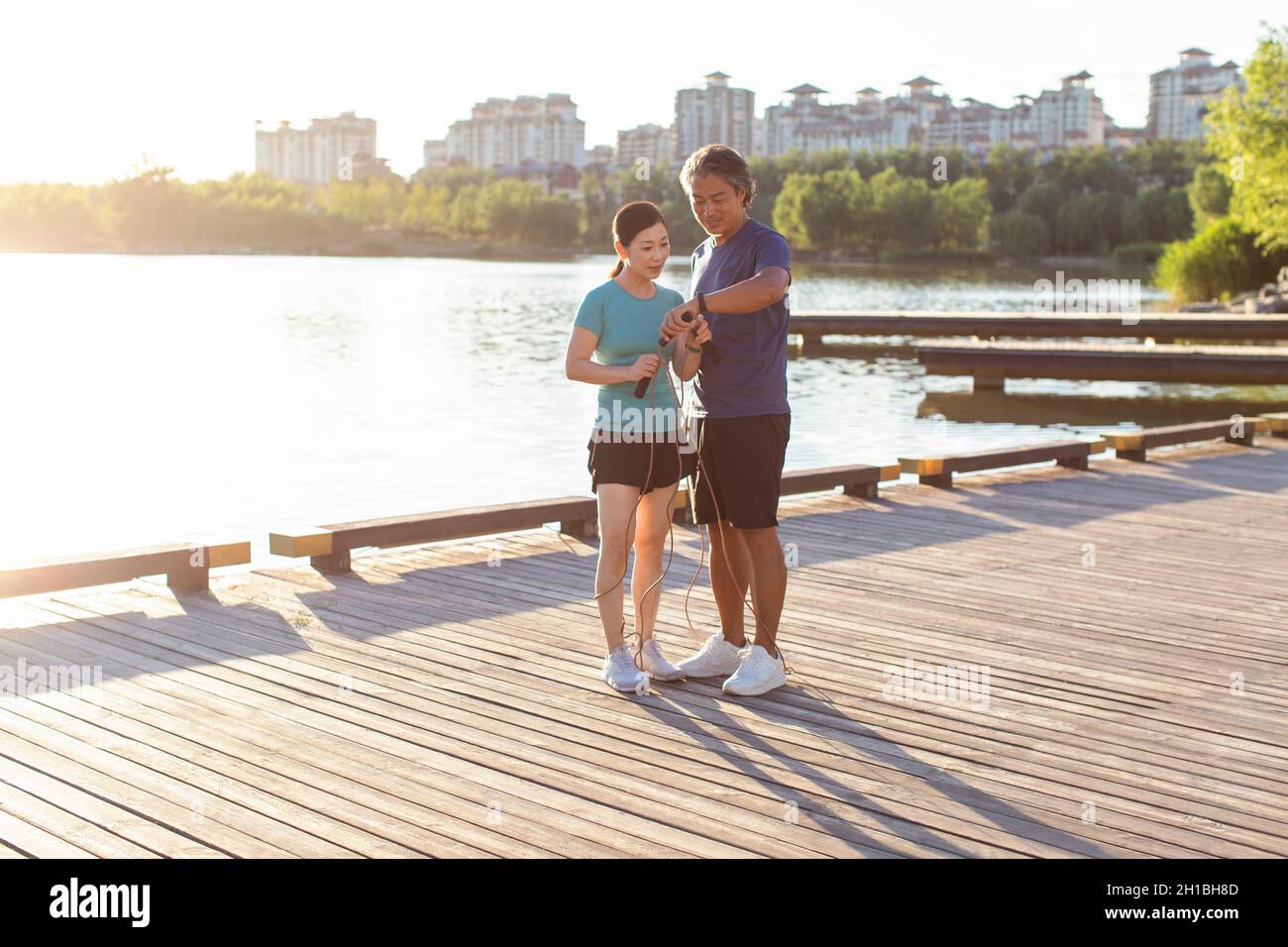 Happy mature couple exercising in park Stock Photo - Alamy