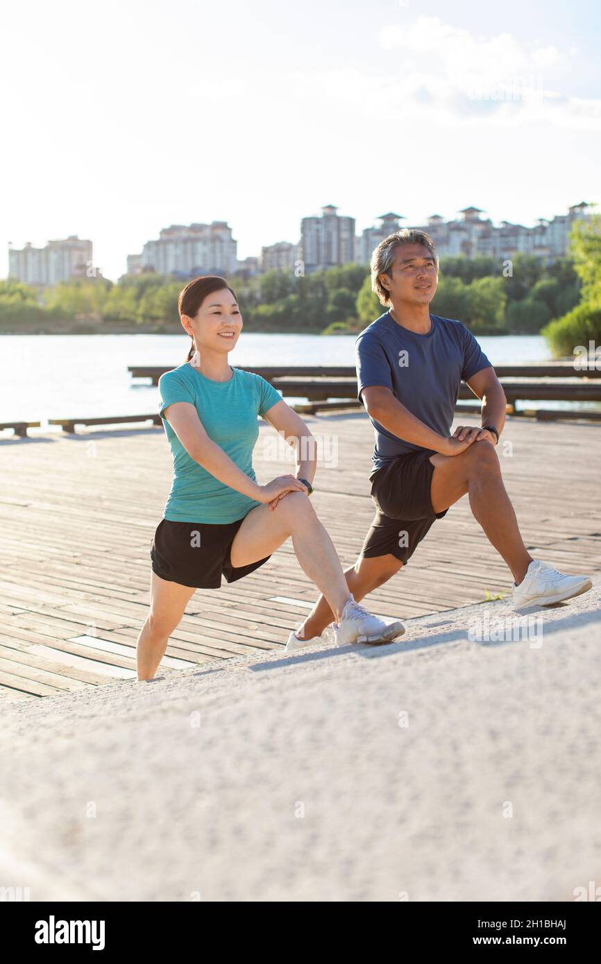 Happy mature couple exercising in park Stock Photo - Alamy