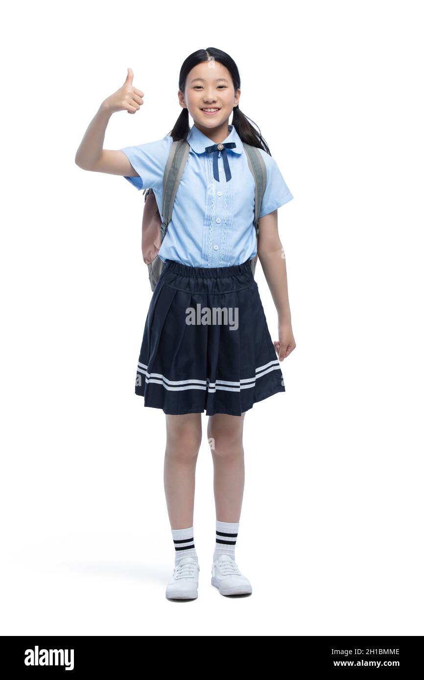 Cheerful schoolgirl doing thumbs up Stock Photo - Alamy