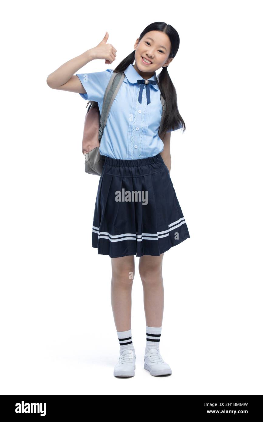 Cheerful schoolgirl doing thumbs up Stock Photo - Alamy