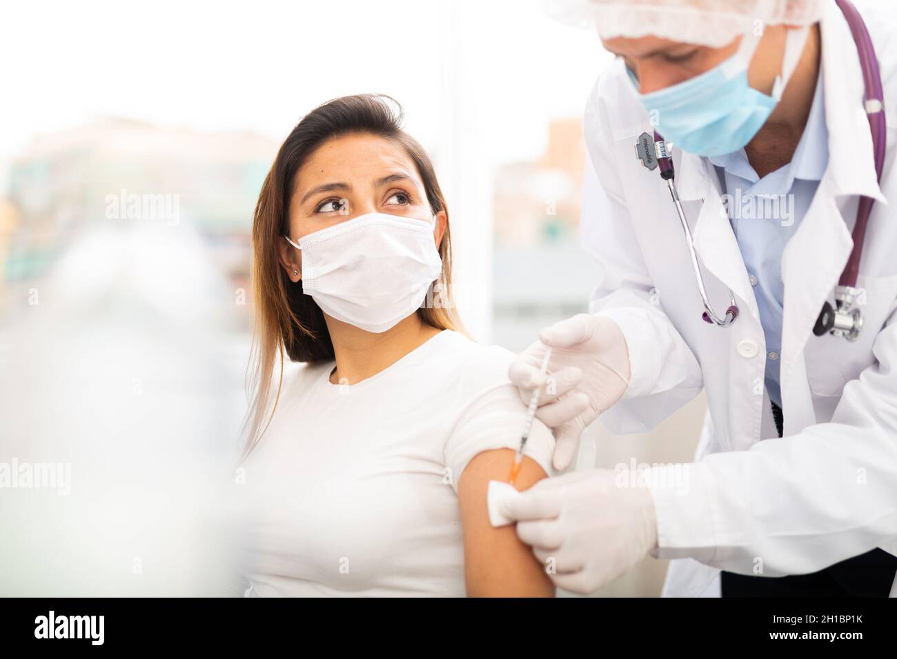 Doctor ready to make injection to adult female visitor Stock Photo - Alamy
