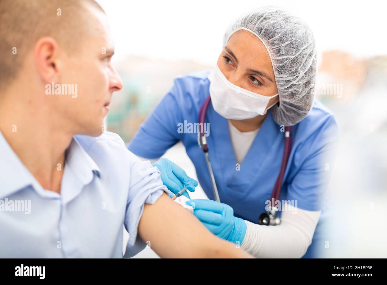 Female doctor ready to make injection to visitor in hospital Stock ...