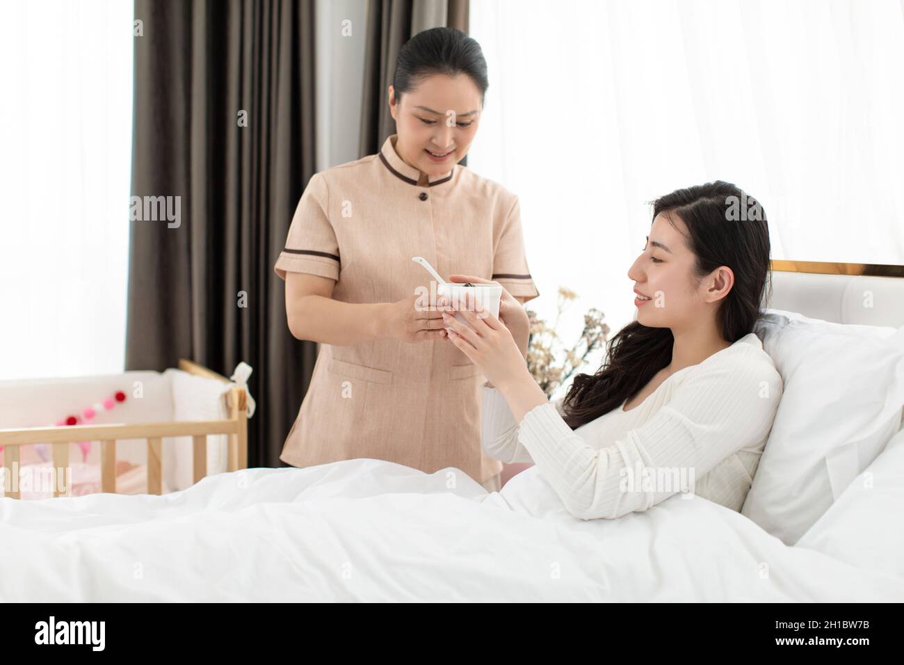 Confinement nurse taking care of young woman Stock Photo Alamy
