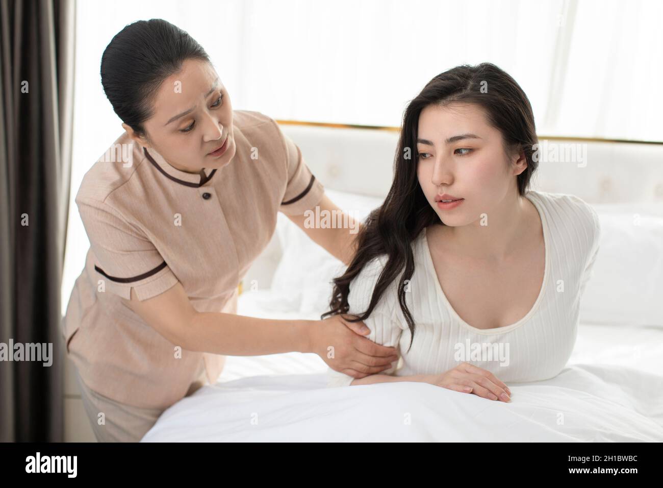 Confinement nurse taking care of young woman Stock Photo Alamy