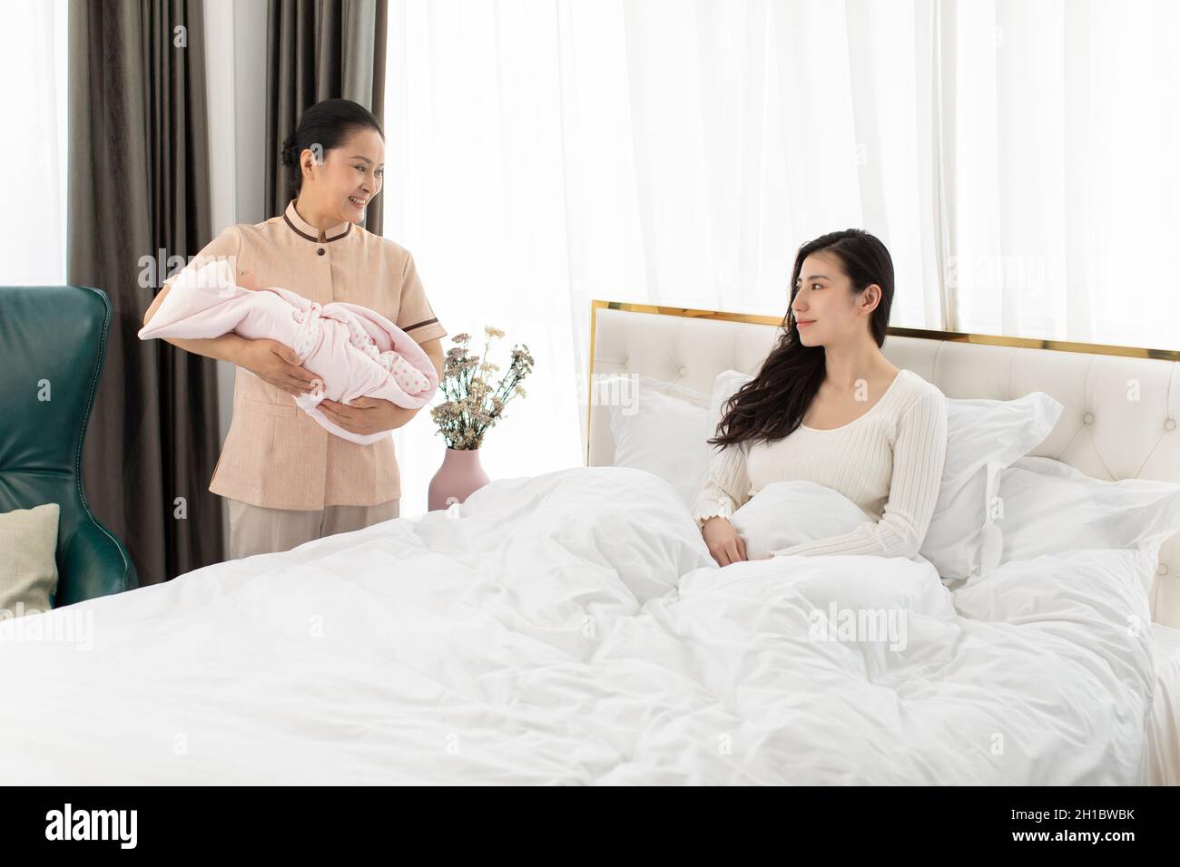 Confinement nurse taking care of young mother and baby Stock Photo Alamy