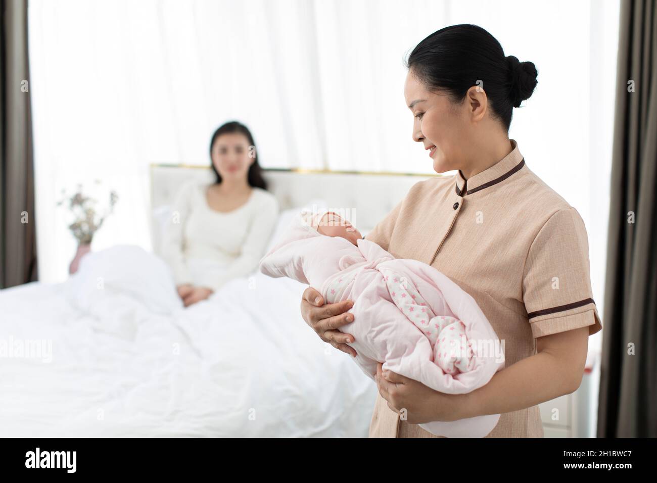 Confinement nurse taking care of young mother and baby Stock Photo Alamy