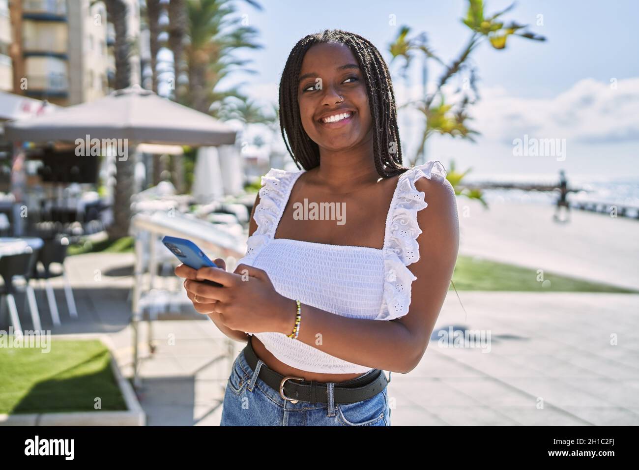 Young african american girl smiling happy using smartphone at the ...