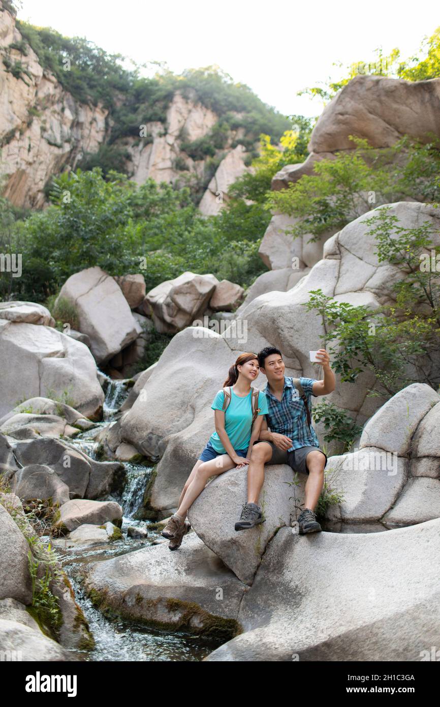 Happy young couple using smart phone outdoors Stock Photo
