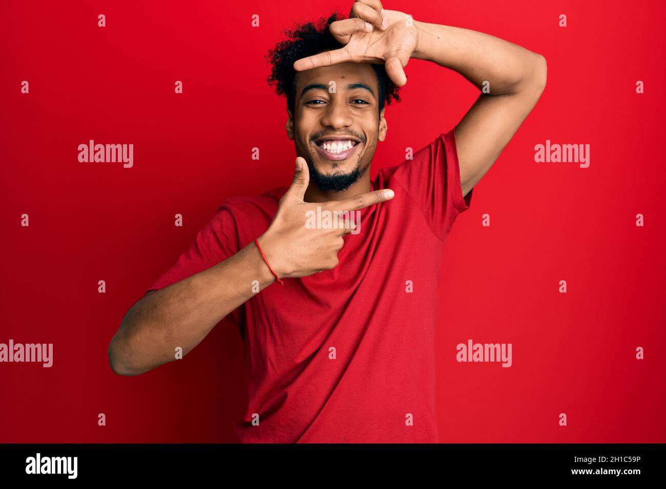 Young african american man with beard wearing casual red t shirt ...