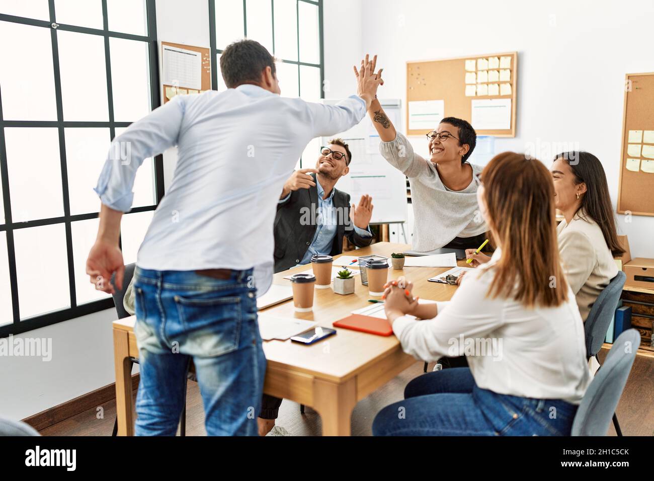 Two workers smiling happy high five during meeting at the office Stock ...