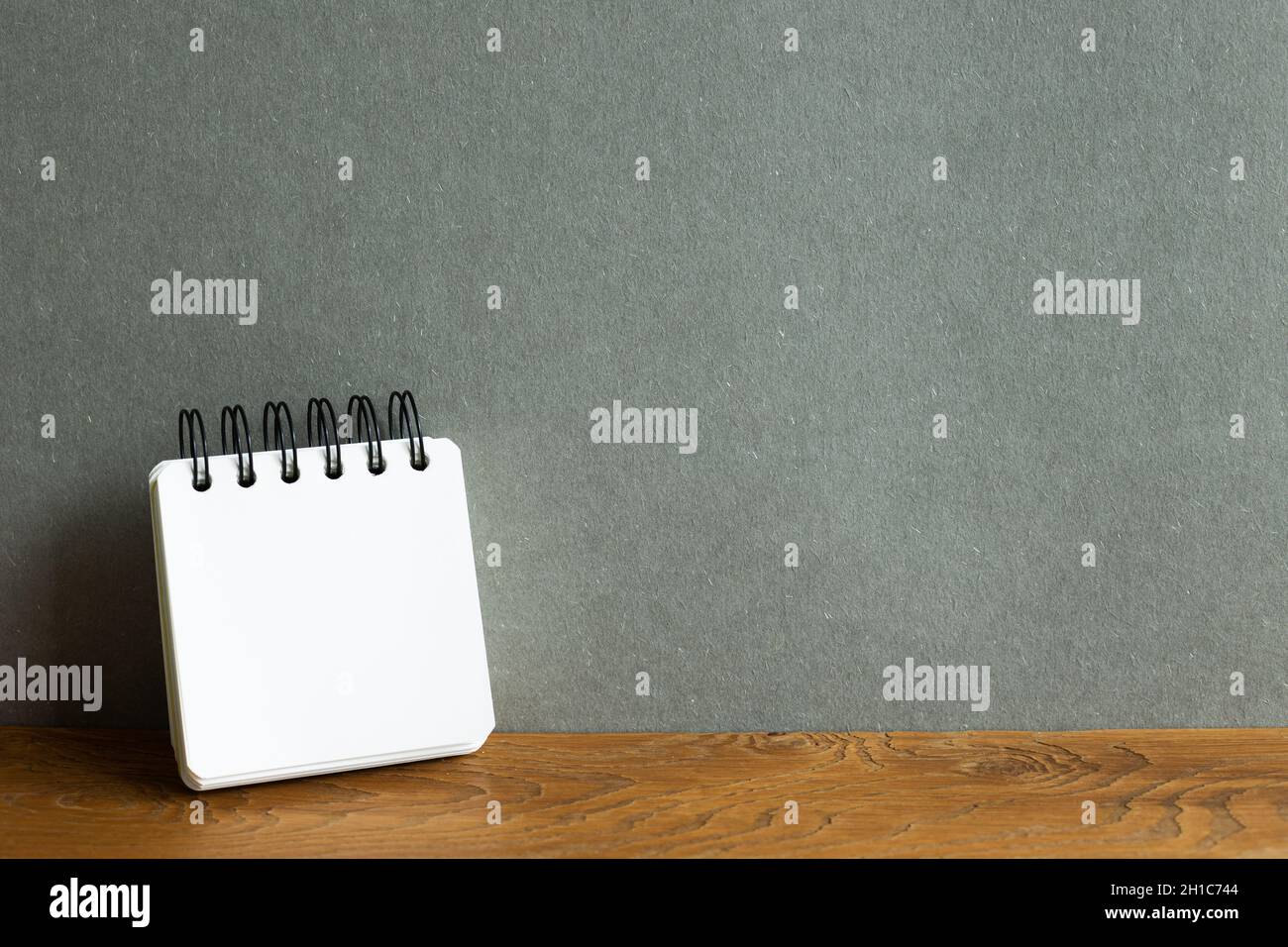 Blank notebook on wooden desk. gray wall background Stock Photo