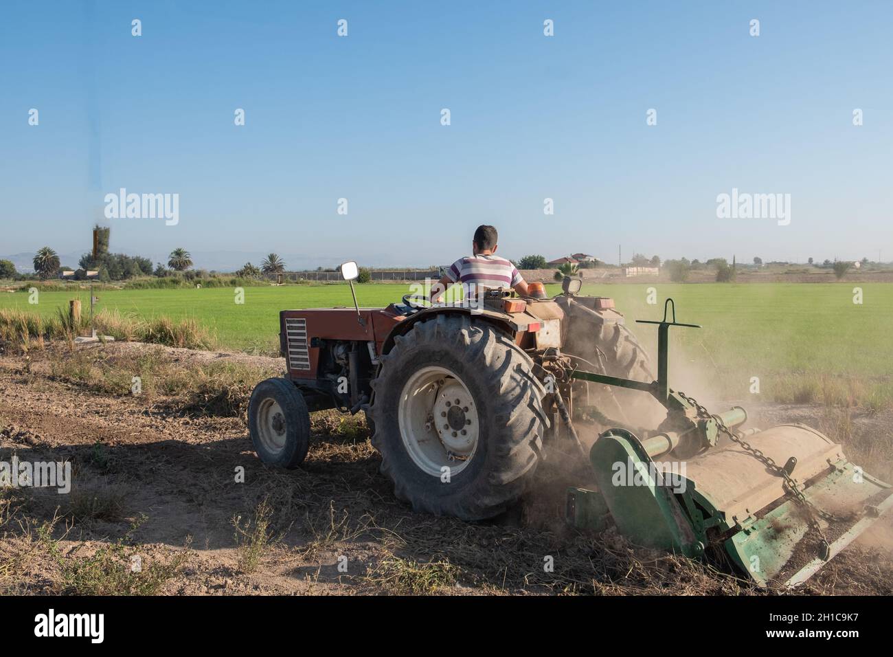 farmer tilling the land to start a new harvest Stock Photo Alamy