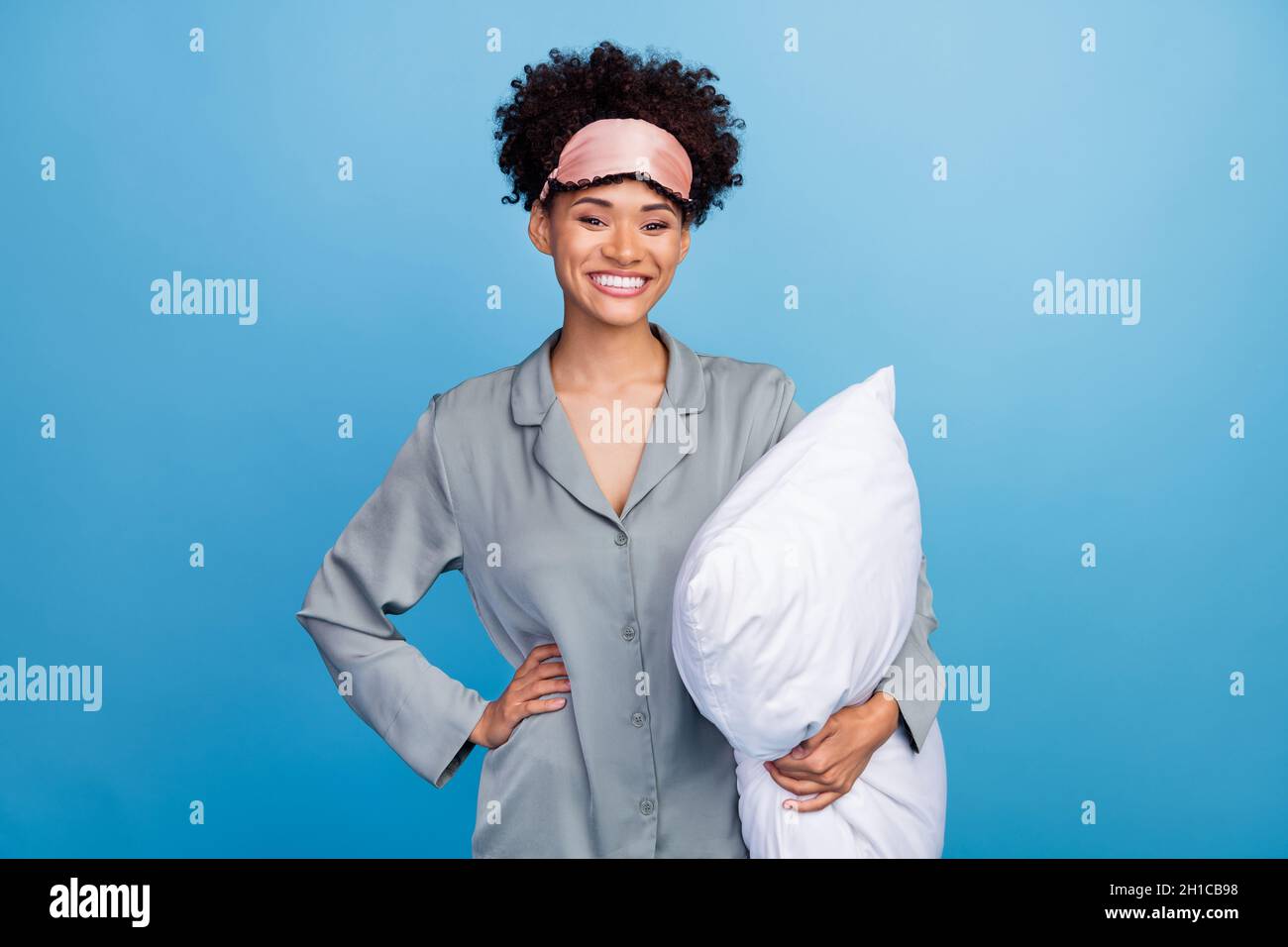 Cheerful Young African Woman Holding A Pillow And Sitting On The