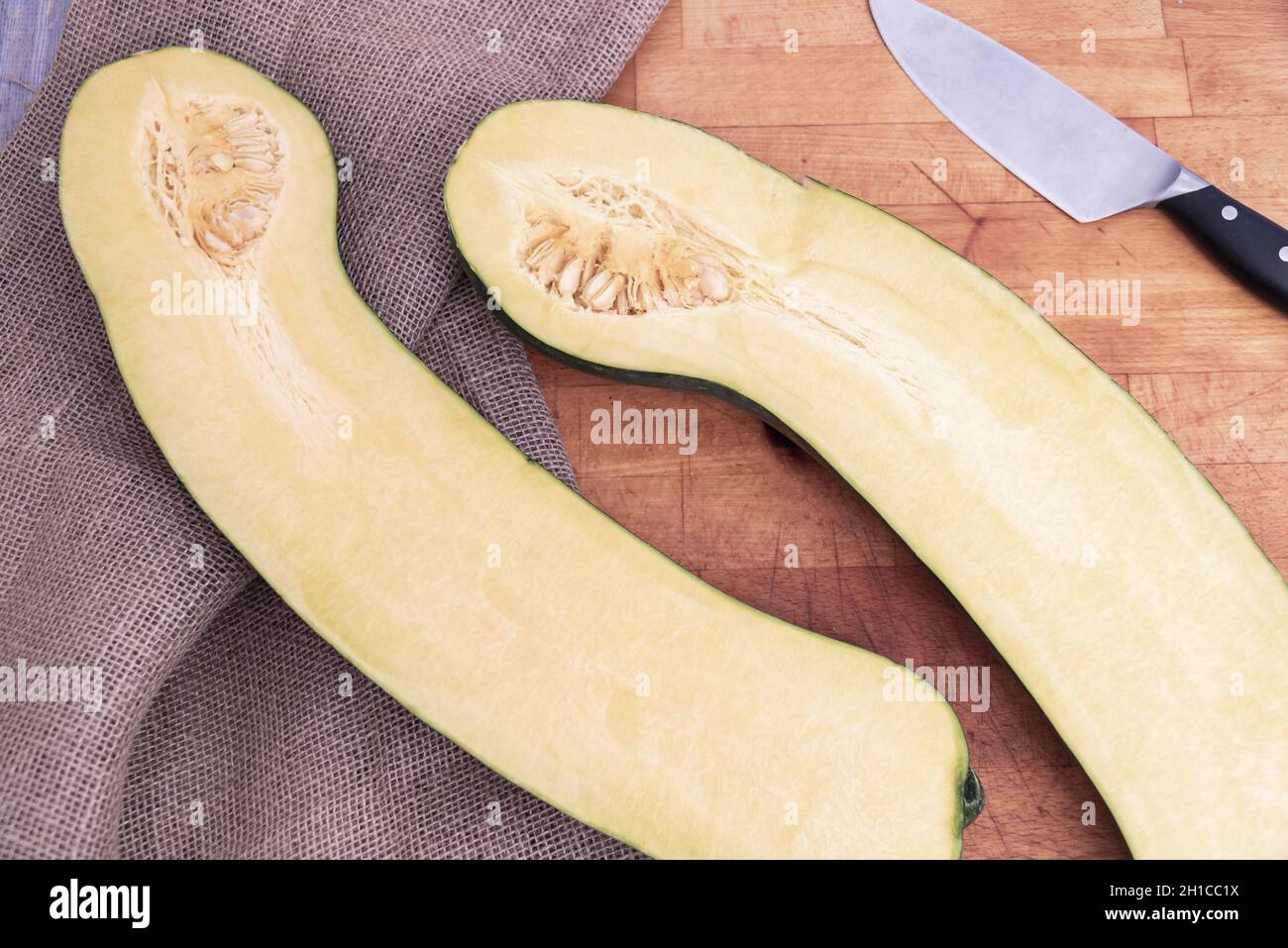 Large pumpkin cut in half on cutting board. Stock Photo