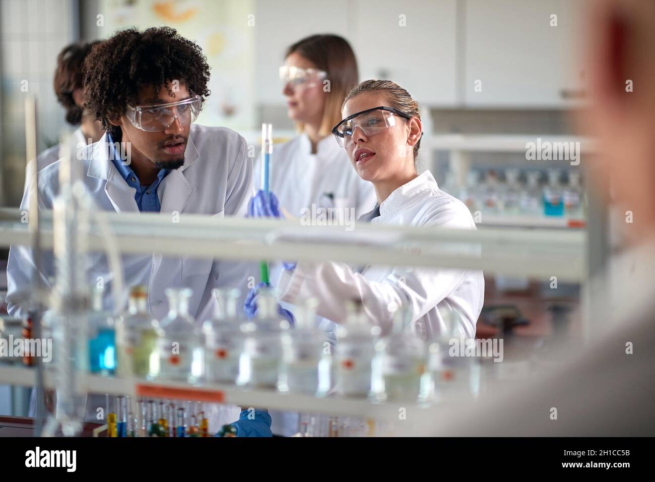 Workers in lab analyze test tube with samples on Corona Stock Photo