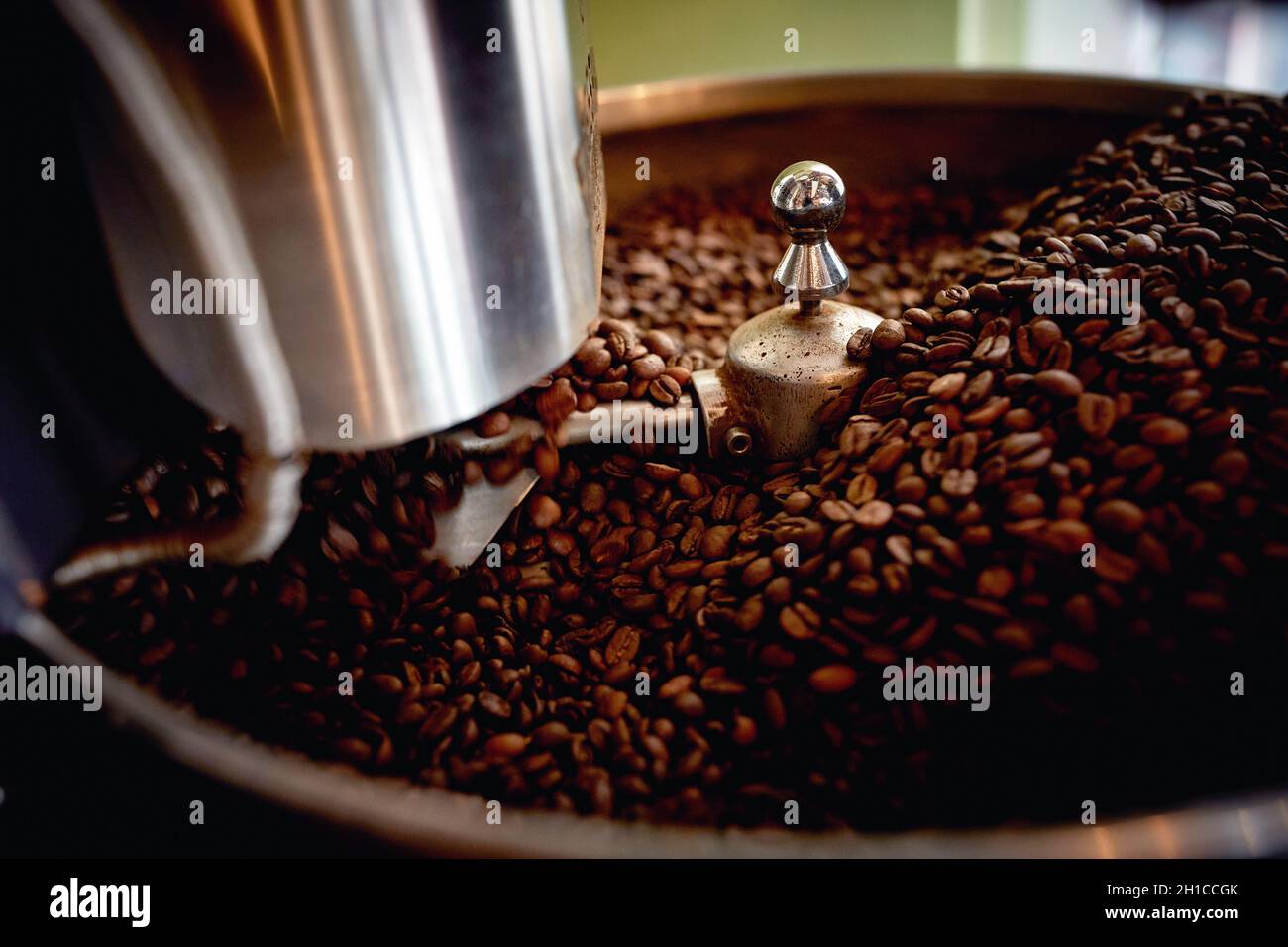 A bunch of fragrant and aromatic roasted coffee beans in a grinder apparatus. Coffee, beverage, producing Stock Photo