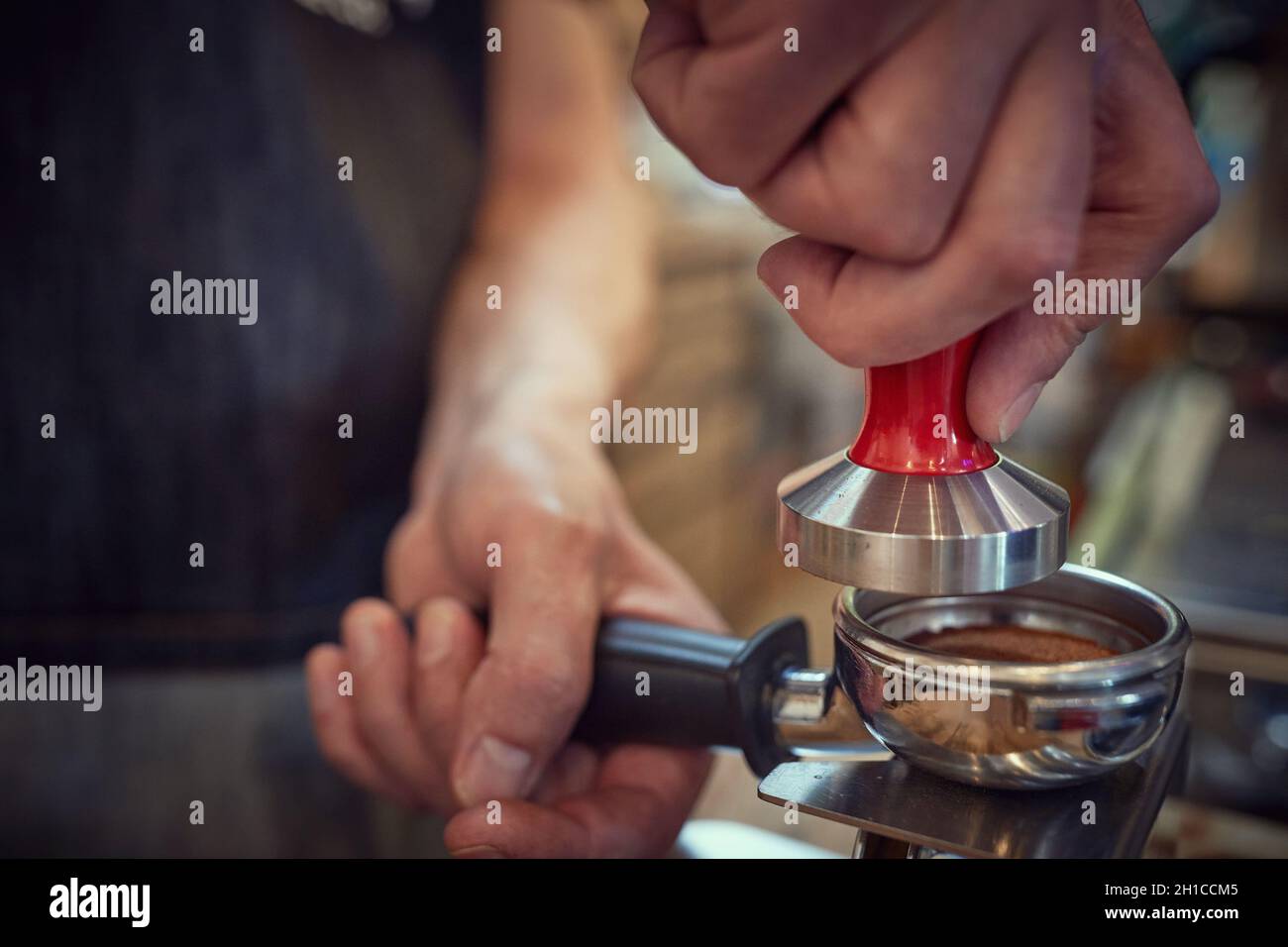 A measure of fragrant and aromatic ground coffee being prepared for espresso by barman. Coffee, beverage, bar Stock Photo