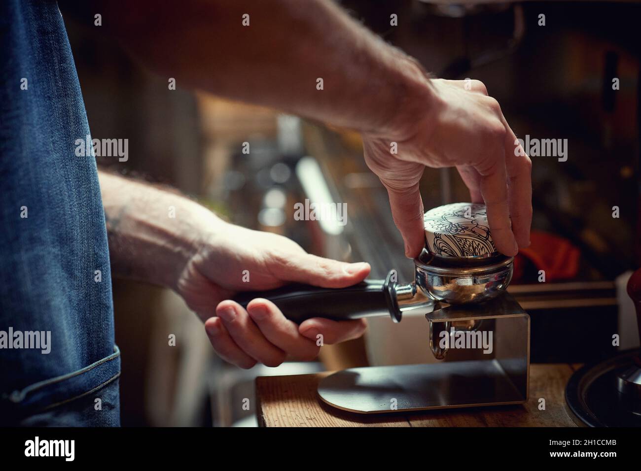 A barman behind the bar is preparing an aromatic and fragrant espresso beverage. Coffee, beverage, bar Stock Photo