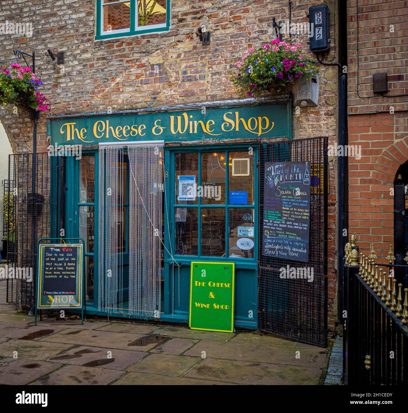 The Cheese and Wine Shop with its hand painted sign and chain flyscreen. An independent retailer in Clarks Yard. Darlington, UK Stock Photo