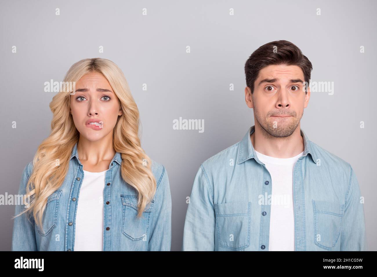 Photo of young couple worried nervous bite lips teeth fail problem anxious isolated over grey color background Stock Photo