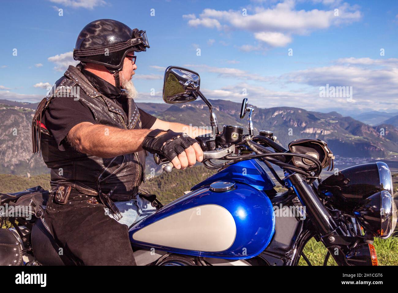 guy riding a retro cruiser motorcycle on mountain road in South tyrol