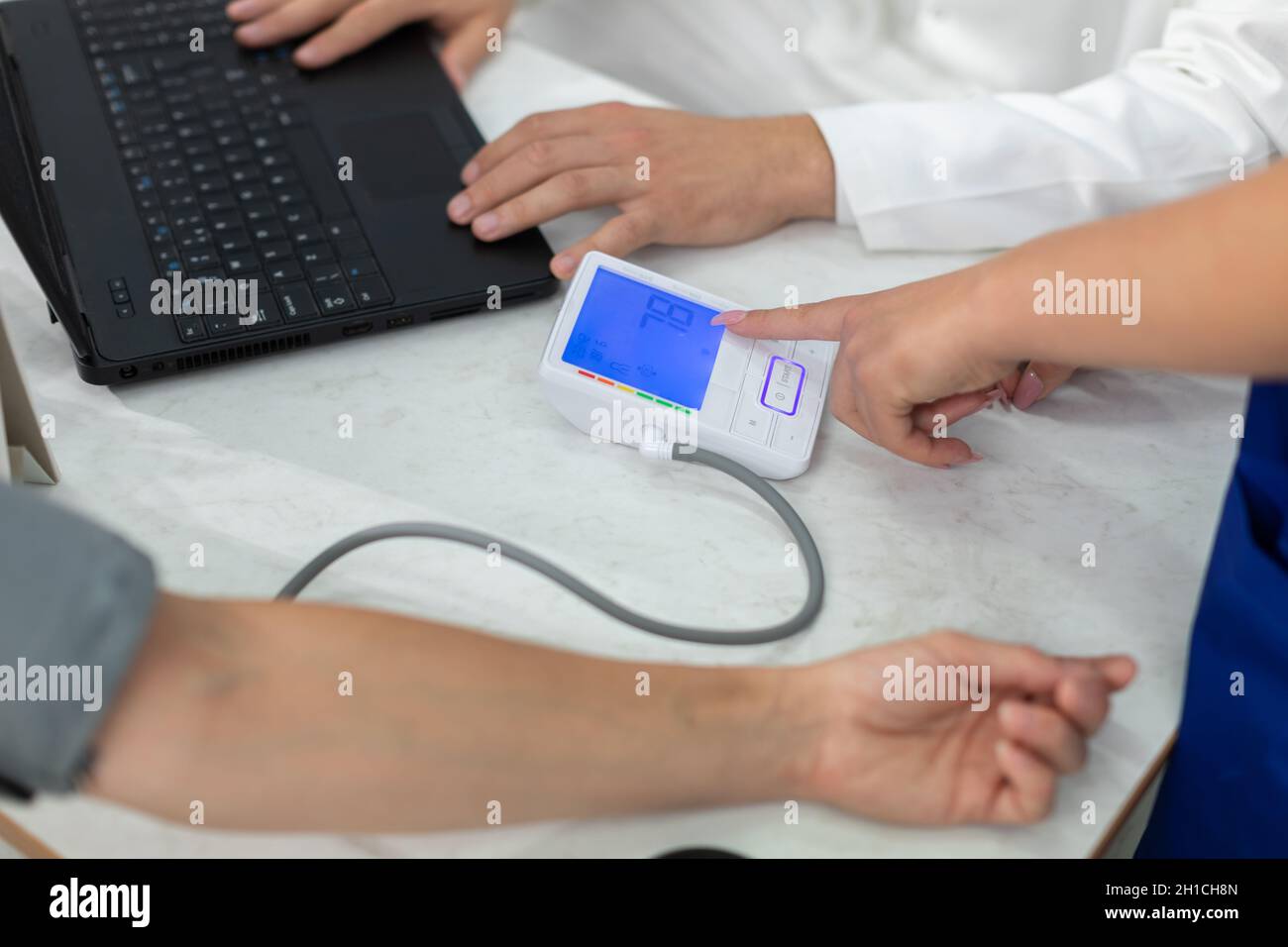 The nurse indicates the result of the lower blood pressure test Stock