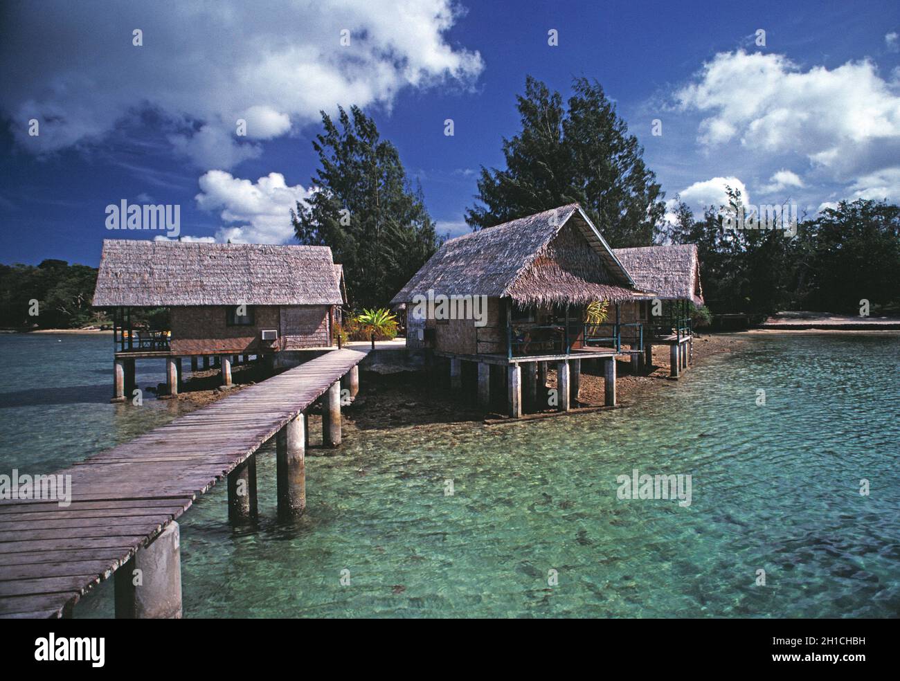 Vanuatu. Efate. Port Vila. Overwater thatched bungalow huts on waterfront. Stock Photo