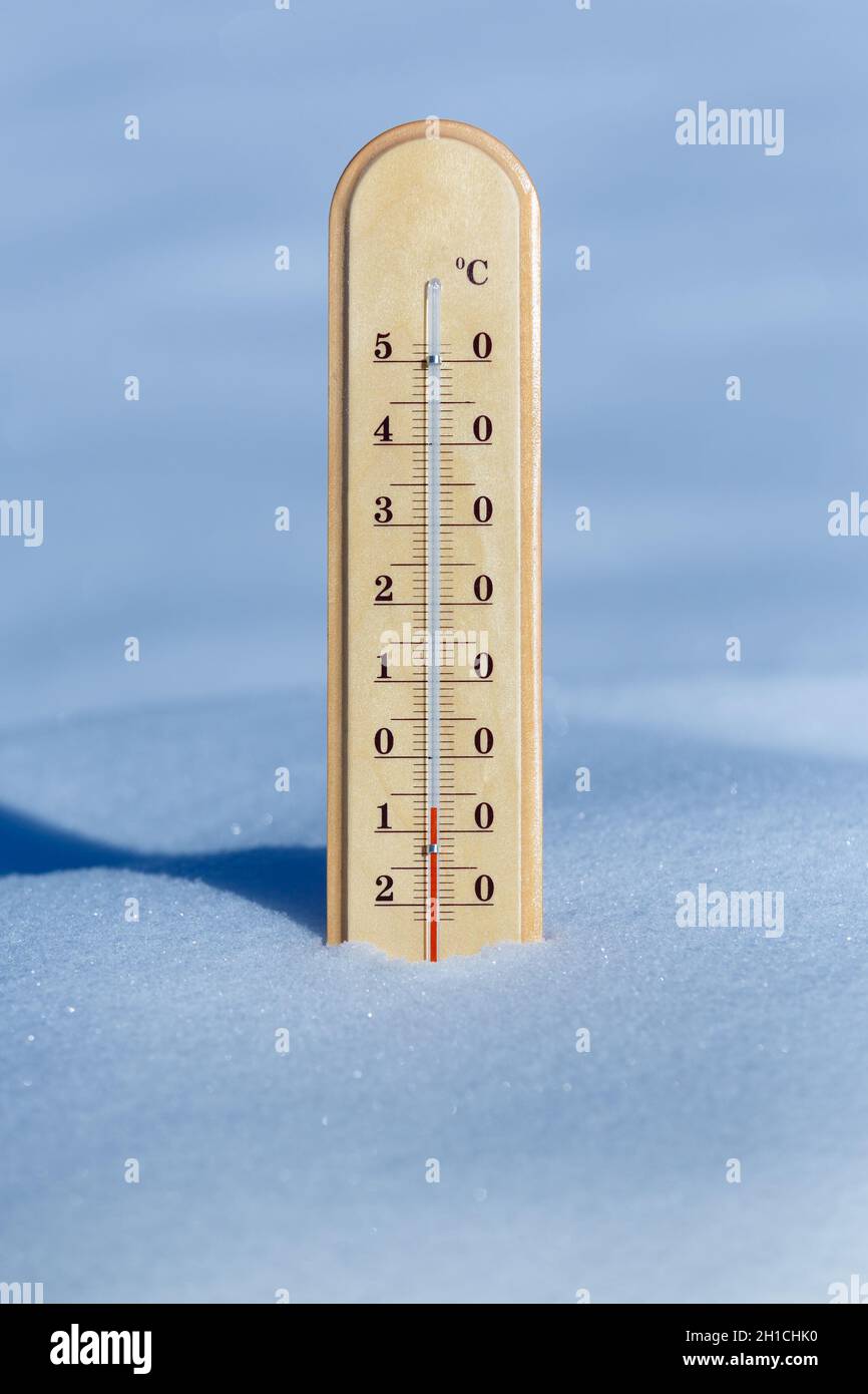 A thermometer in blue snow shows a temperature of -7 degrees Celsius Stock Photo