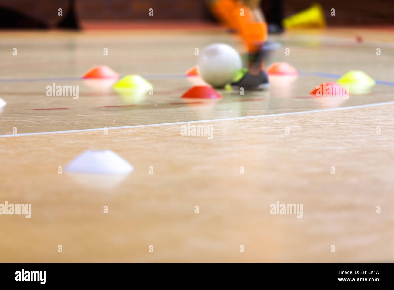 Indoor soccer player training with a white futsal ball. Futsal training
